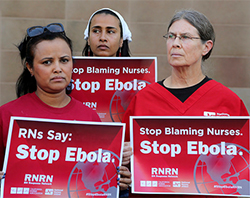 three women in red holding signs that say 'Stop Ebola'