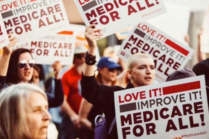protesters holding medicare for all signs