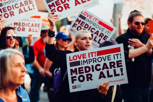 people protesting holding love it! improve it! medicare for all!